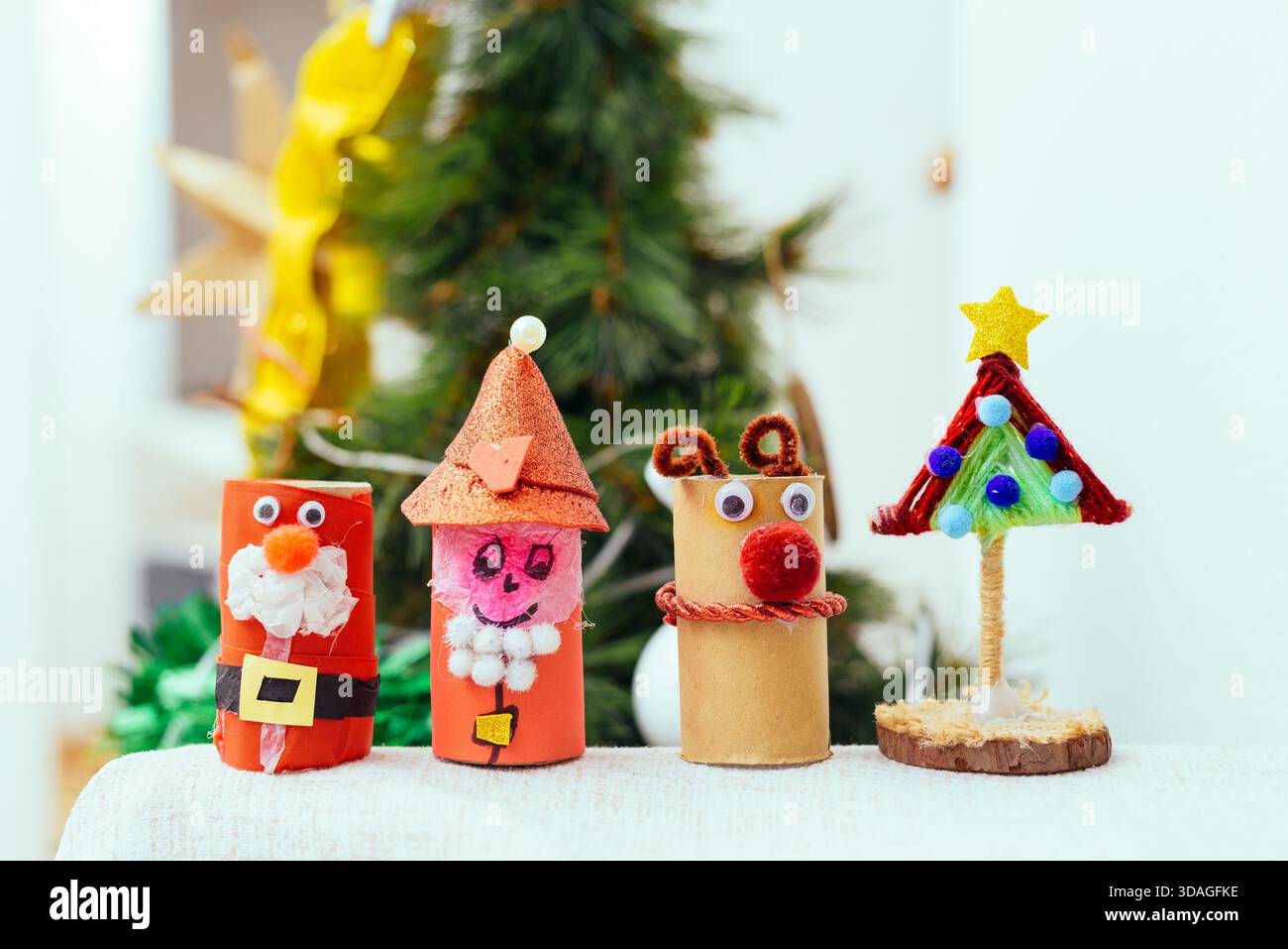 Kinder kreieren Weihnachtsbasteln mit Pappröhrchen und zeigen Kreativität und festliche Stimmung während der Weihnachtsvorbereitungen. Stockfoto
