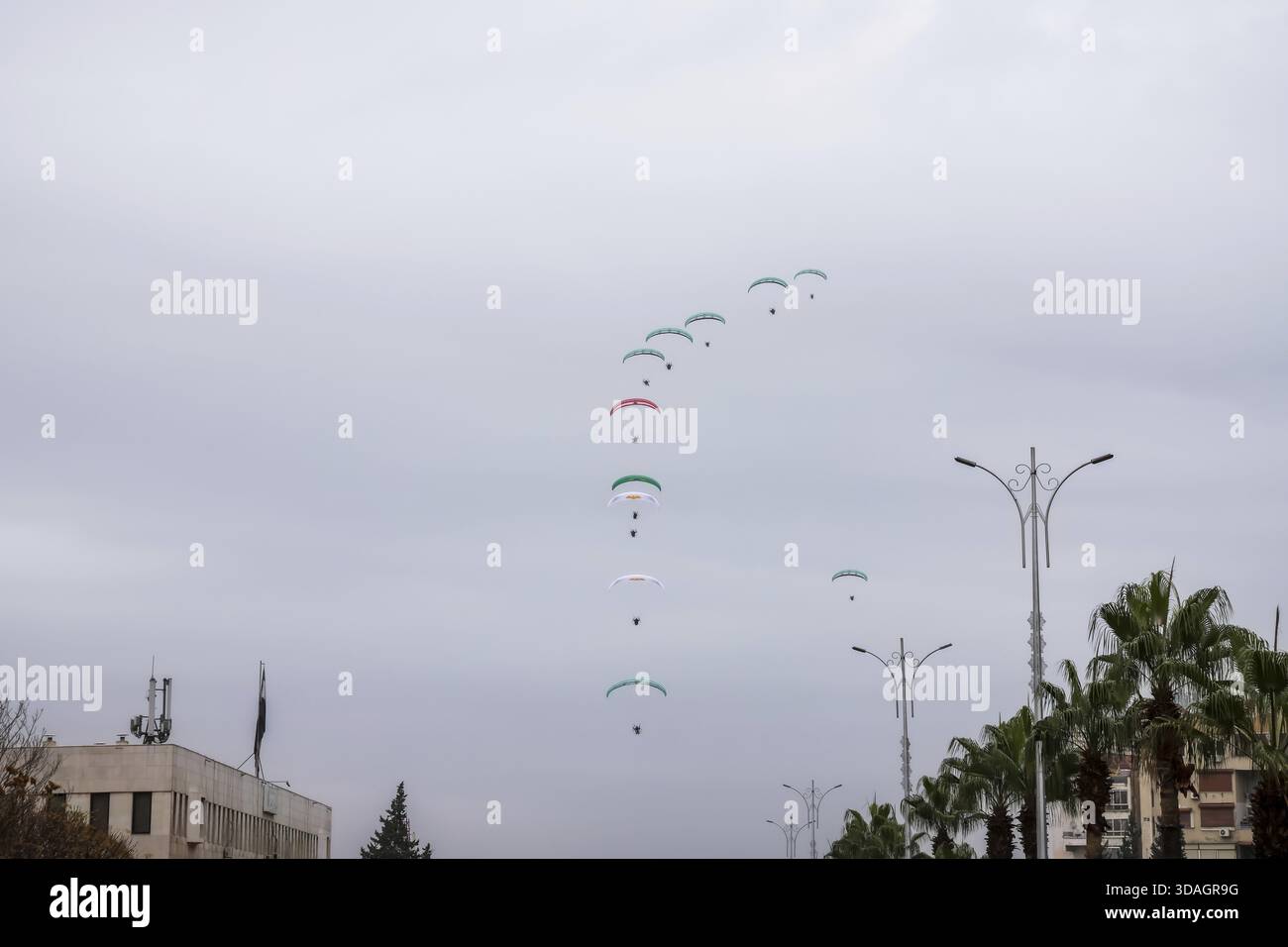 Damaskus, Syrien â€“ 08. Dezember 2025: Gleitschirmflieger zeigen die syrische Flagge während des ersten Jahrestages des Sturzes des Baschar al-Assad-Regimes als hu Stockfoto
