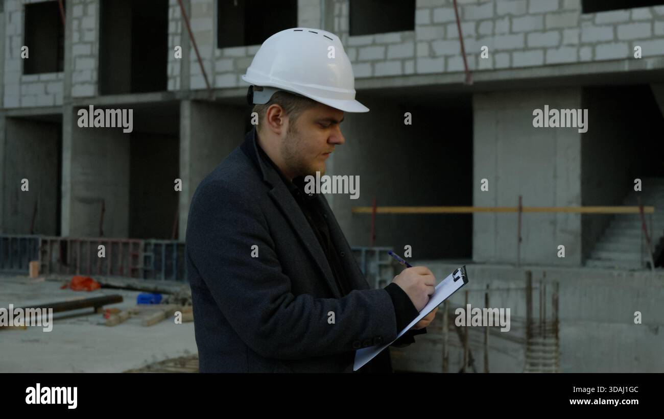 Zwei Bauexperten diskutieren Pläne auf einer Baustelle Stockfoto