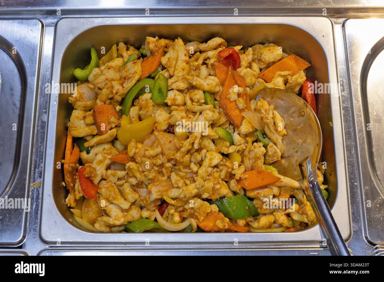 Aus nächster Nähe sehen Sie ein herzhaftes Hühnchen- und Gemüsebraten in einer Scheuerform aus Edelstahl, die servierfertig ist Stockfoto