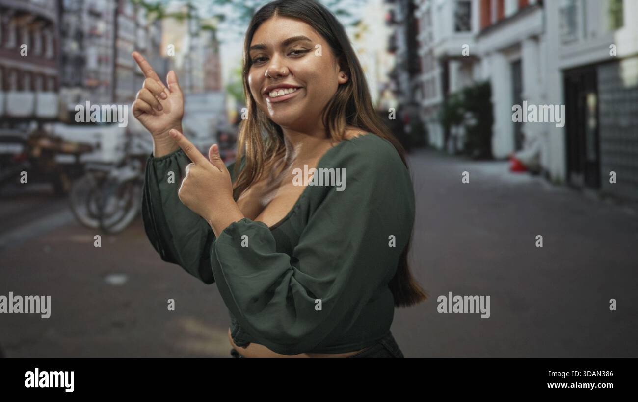 Frau, die mit den Fingern zeigt und auf der Straße ein Dekolleté zeigt, Fahrräder und Gebäude sichtbar; Selbstbewusstsein. Stockfoto