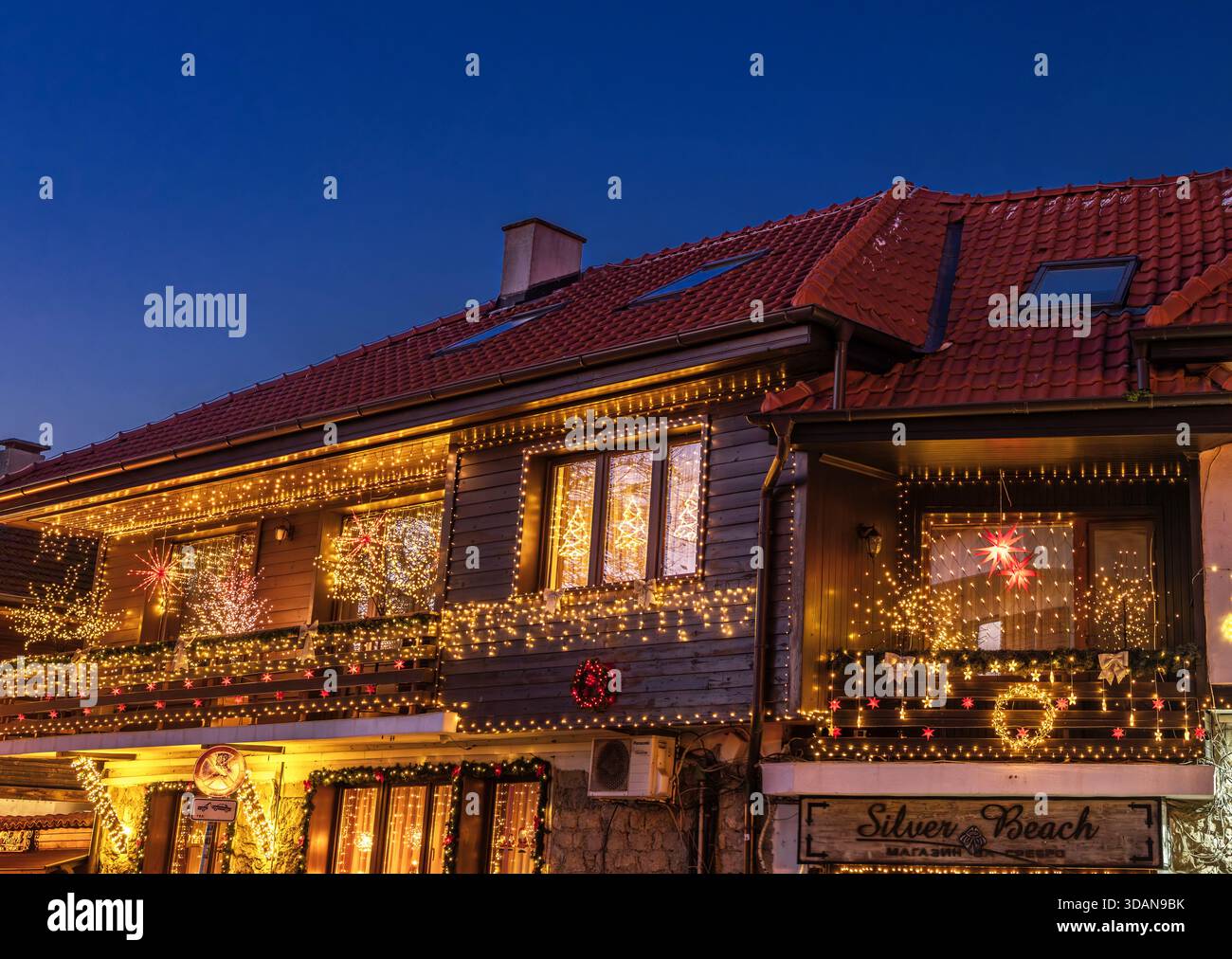 Ein charmantes Haus mit warmen Weihnachtslichtern am Abend in der Altstadt von Nessebar, Burgas, Bulgarien Stockfoto