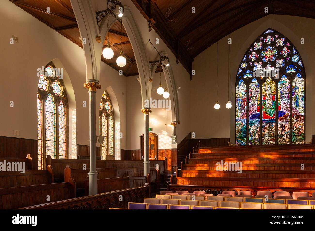 Alte hölzerne Kirchenbänke und Buntglasfenster in St. Brycedale Church, Kirkcaldy, Fife, Schottland Stockfoto