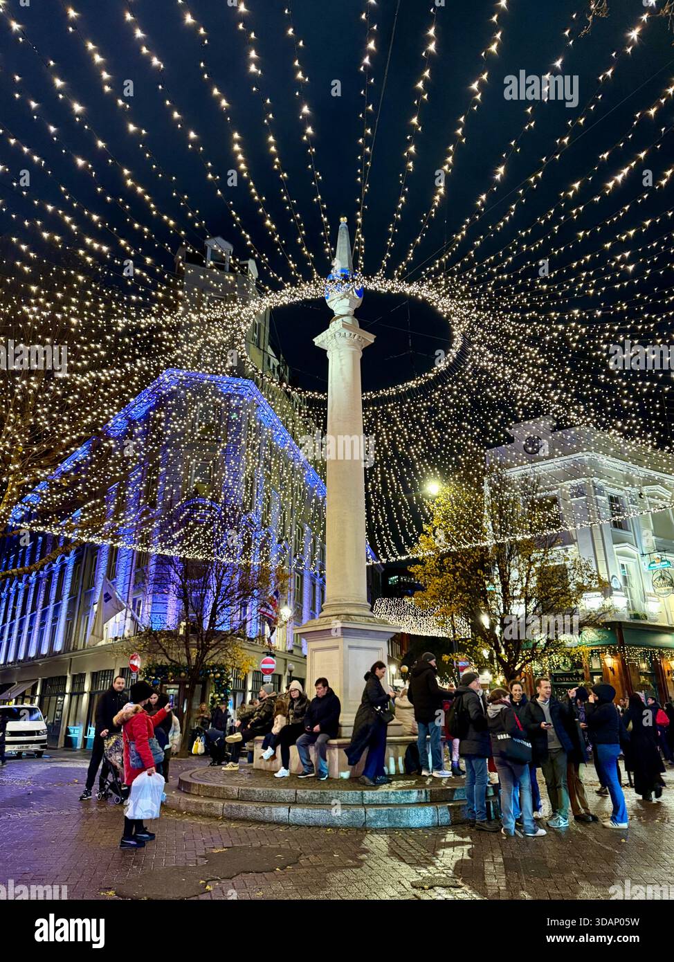 Covent Garden London, Viertel Seven Dials, Sonnenkalve, beleuchtete Weihnachtsbeleuchtung. Leute, die herumlaufen. Nachts aufgenommen. Stockfoto
