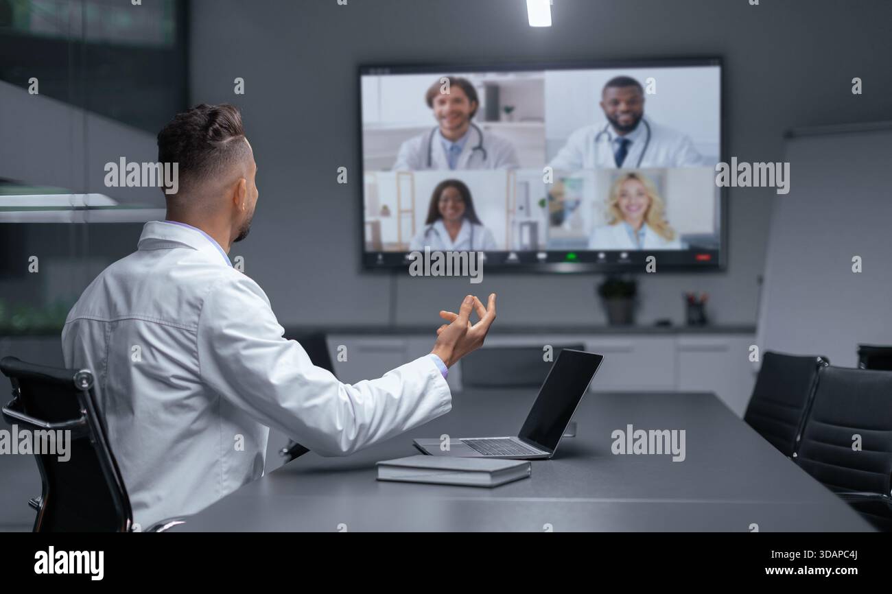 Medizinische Fachkräfte interagieren abends während eines virtuellen Meetings in einem Konferenzraum Stockfoto