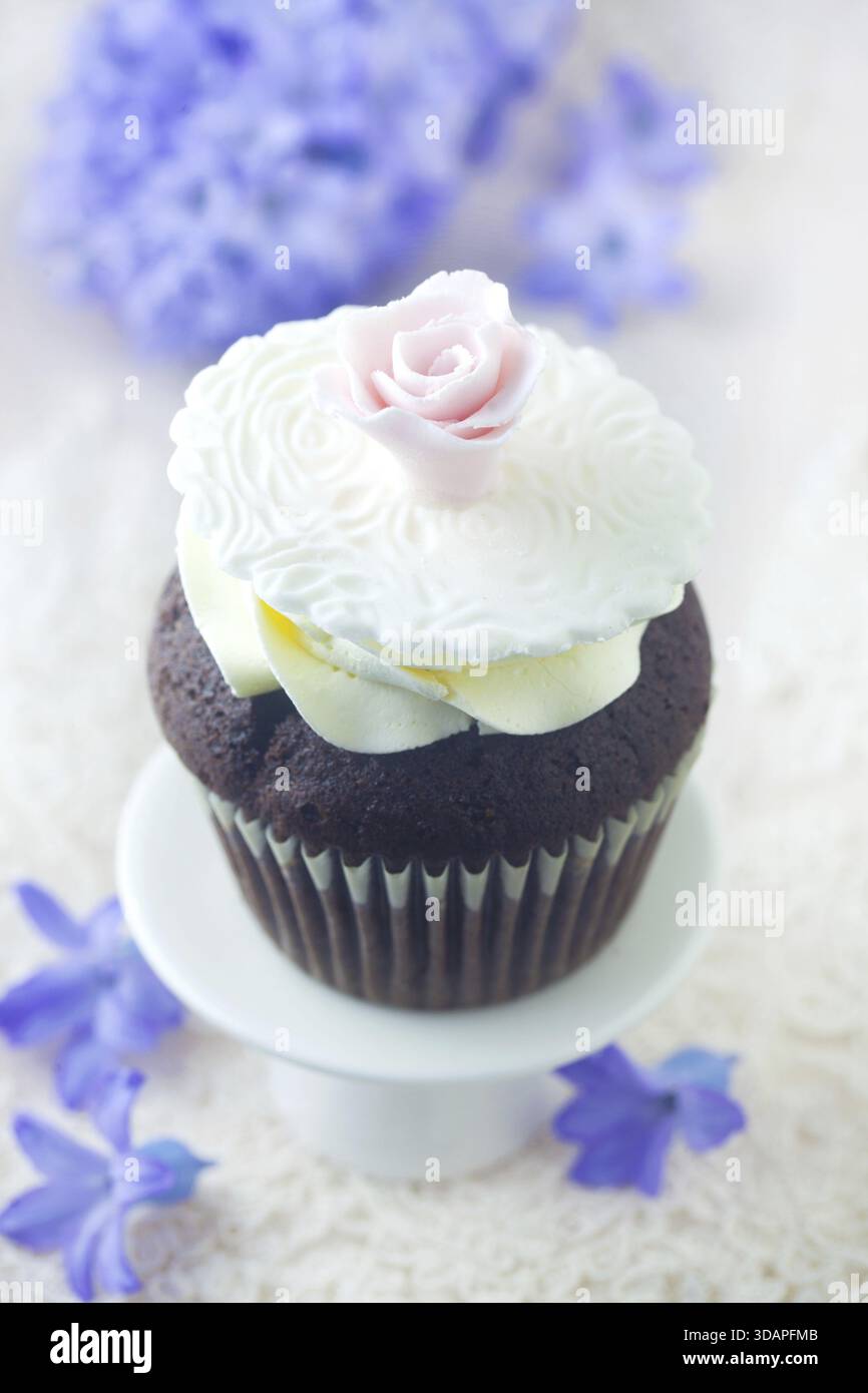 Essen, anmutiger Cupcake dekoriert mit Einer rosa Rose Stockfoto