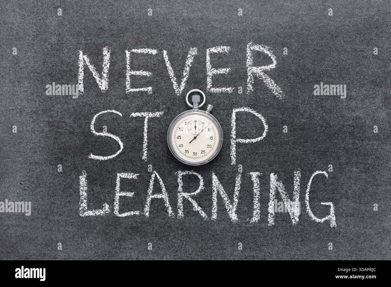 Hören Sie nie auf, einen Satz zu lernen, der handgeschrieben auf der Tafel mit einer präzisen Vintage-Stoppuhr anstelle von O geschrieben wurde Stockfoto
