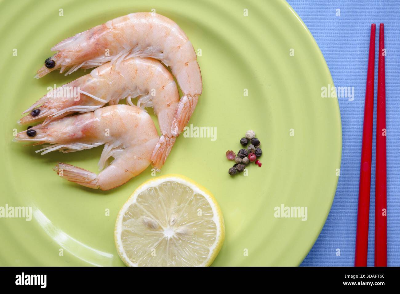 Shrimps-Portion auf grüner Platte mit Zitronenscheibe Stockfoto