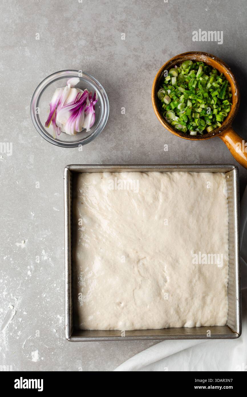 Draufsicht der Focaccia-Teigprüfung in der Backform, Draufsicht eines Focaccia-Brotteigs mit hoher Flüssigkeitszufuhr in einer Pfanne Stockfoto