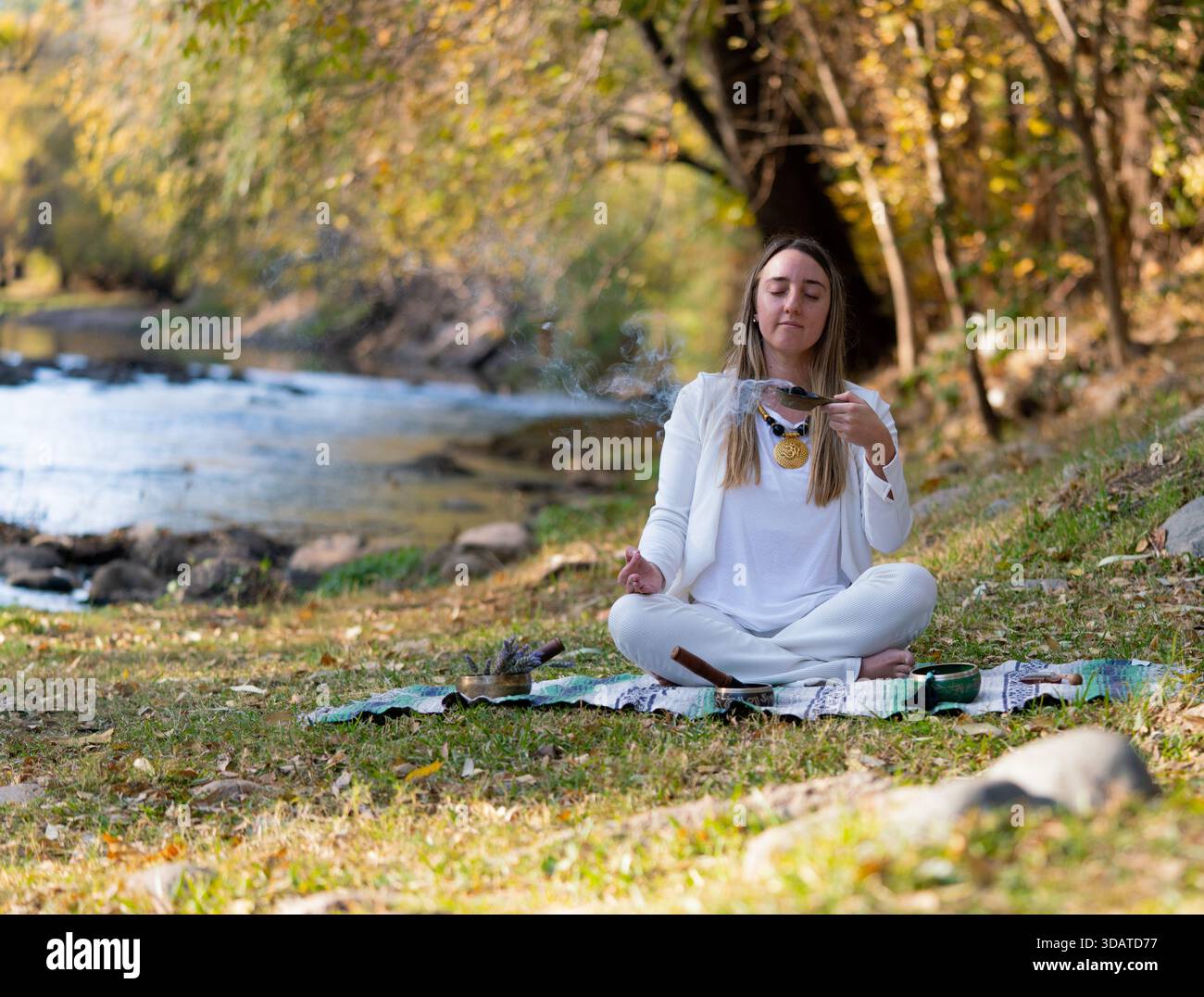 Frau verschmiert Salbeibündel für spirituelle Reinigung im Freien Stockfoto