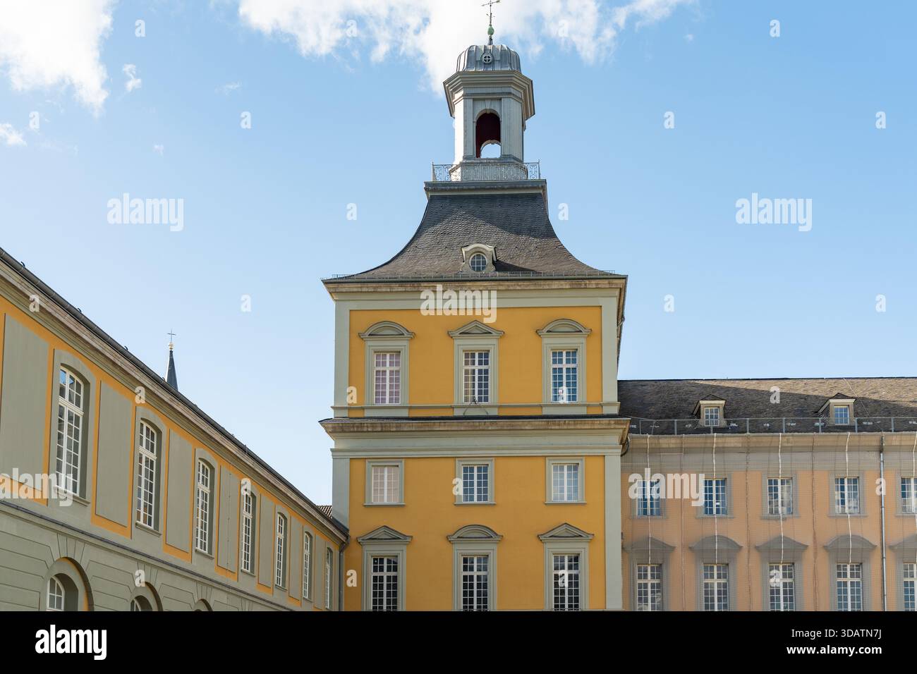 Der Blick auf den markanten gelben Universitätsturm erhebt sich vor einem klaren blauen Himmel, ein Wahrzeichen umrahmt von den umliegenden Gebäuden, Bonn, Nordrhein-Westpha Stockfoto