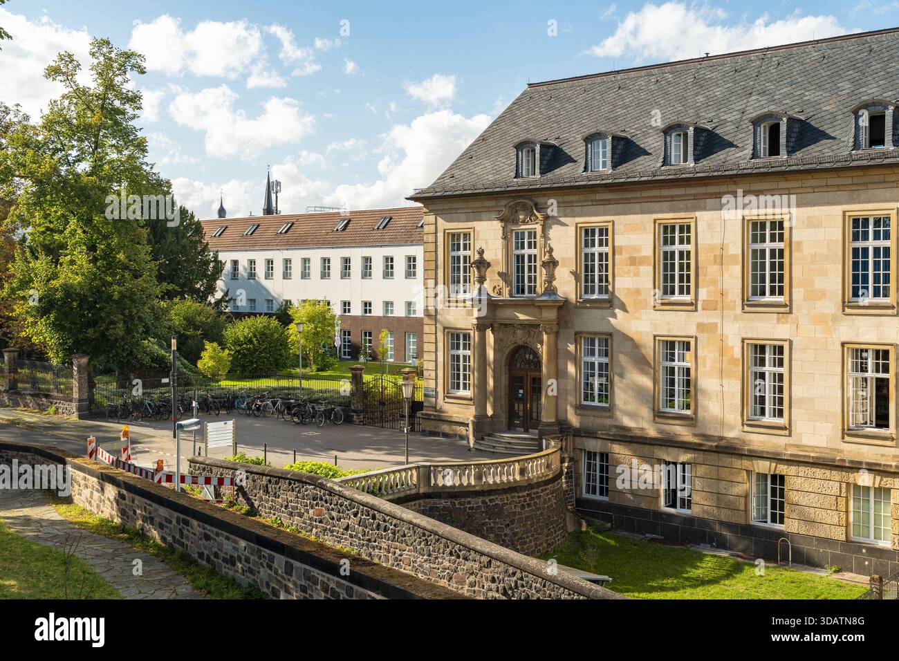 Der Blick auf sonnendurchflutete Sandsteinfelder Universitätsgebäude steht majestätisch vor der Kulisse von üppigem Grün und hellem Himmel, Bonn, Nordrhein-Westfalen Stockfoto