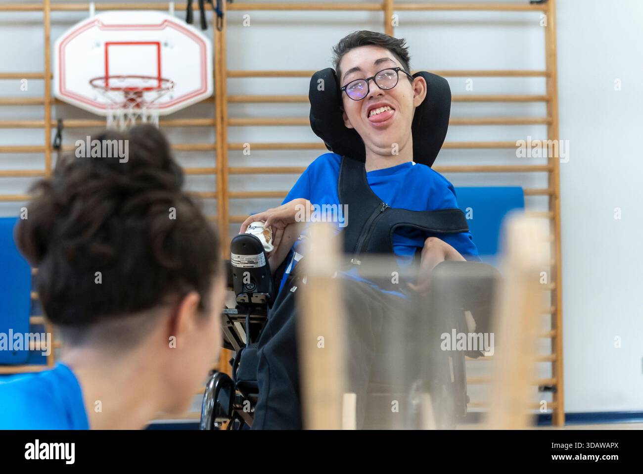 Boccia-Spieler mit Zerebralparese nehmen an einem dynamischen Training mit seinem Trainer teil, bei dem er sich auf die Verbesserung seiner Fähigkeiten konzentriert. Adaptive Ausrüstung unterstützt den Stockfoto