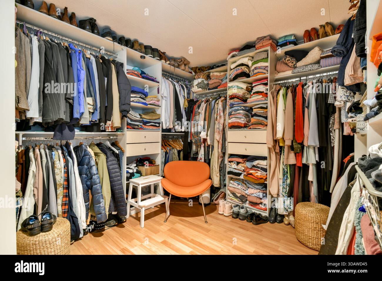 Ein geräumiger und gut organisierter Kleiderschrank mit einer Vielzahl von Kleidungsstücken, Schuhen und Accessoires, die für einfachen Zugang übersichtlich angeordnet sind. Stockfoto