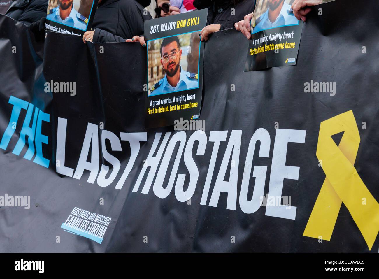 Borehamwood Shopping Park, Großbritannien. Dezember 2025. Bei der wöchentlichen Geiselwache hören Mitglieder der Gemeinde Elstree und Borehamwood von den Aktionen des IDF-Staff-Sergeant Major ran Gvili am 7. Oktober 2023, der letzten verbliebenen Geisel in Gaza. RAN, der am 9. Oktober wegen einer Operation an seiner gebrochenen Schulter am Kibbutz Alumim operiert werden sollte, kämpfte gegen die Hamas-Kämpfer und half dabei, 100 Menschen vom Nova-Musikfestival zu retten. Aufgrund ihres Heldentums wurde an diesem Tag kein einziger Bewohner des Kibbuz Alumim ermordet oder entführt. Quelle: Amanda Rose/Alamy Live News Stockfoto
