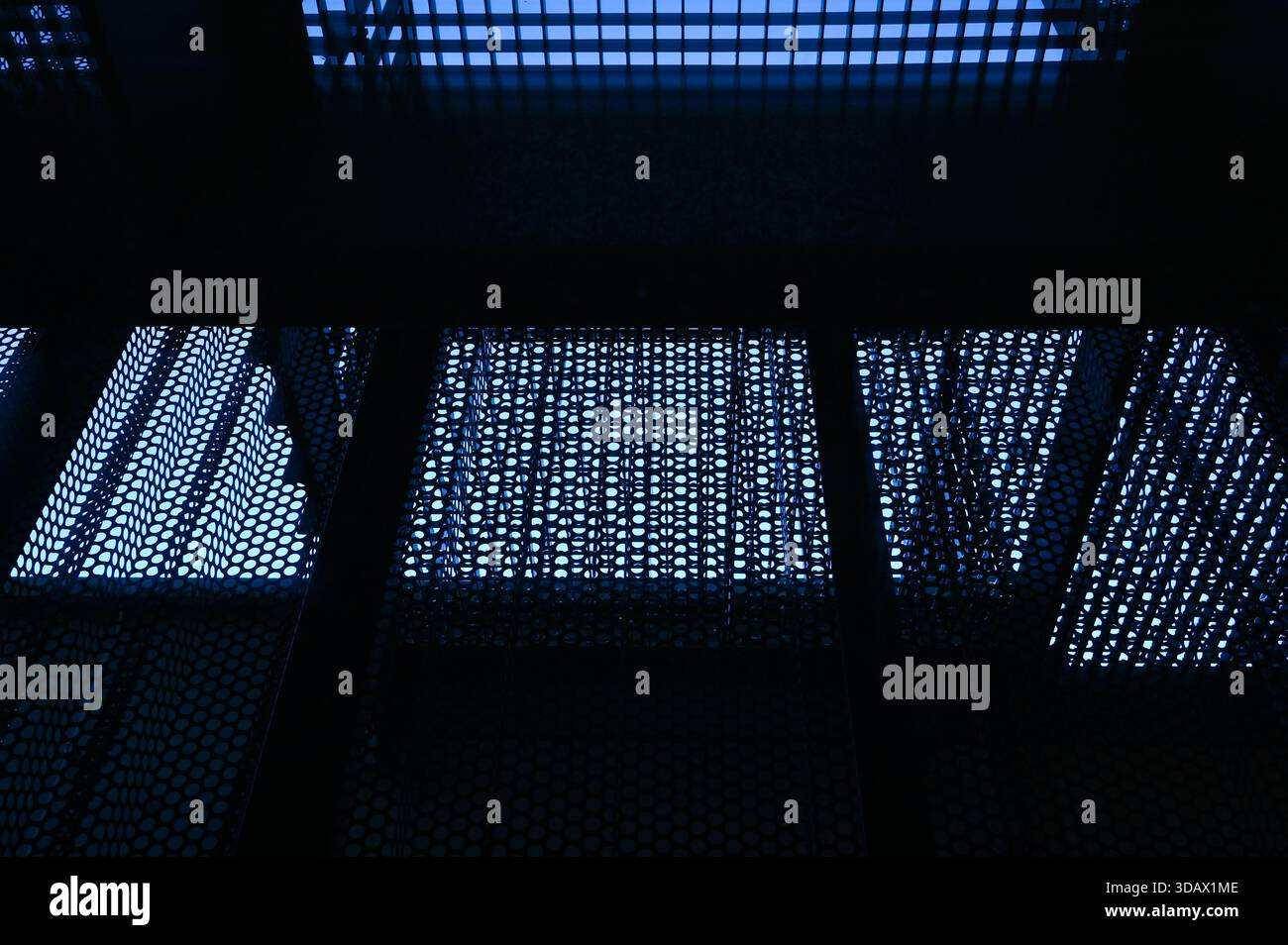 Blauer Hintergrund aus perforiertem Blech aus Edelstahl. Stockfoto