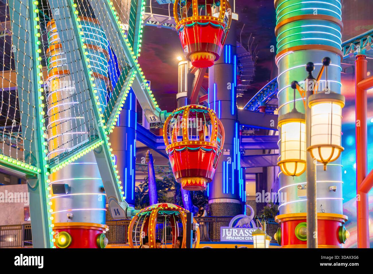 Farbenfrohe Heißluftballonfahrten und Riesenradkonstruktionen beleuchten den Indoor-Freizeitpark Genting Highlands. Lebhaftes Familienunterhaltungskonzept. Aufregen Stockfoto