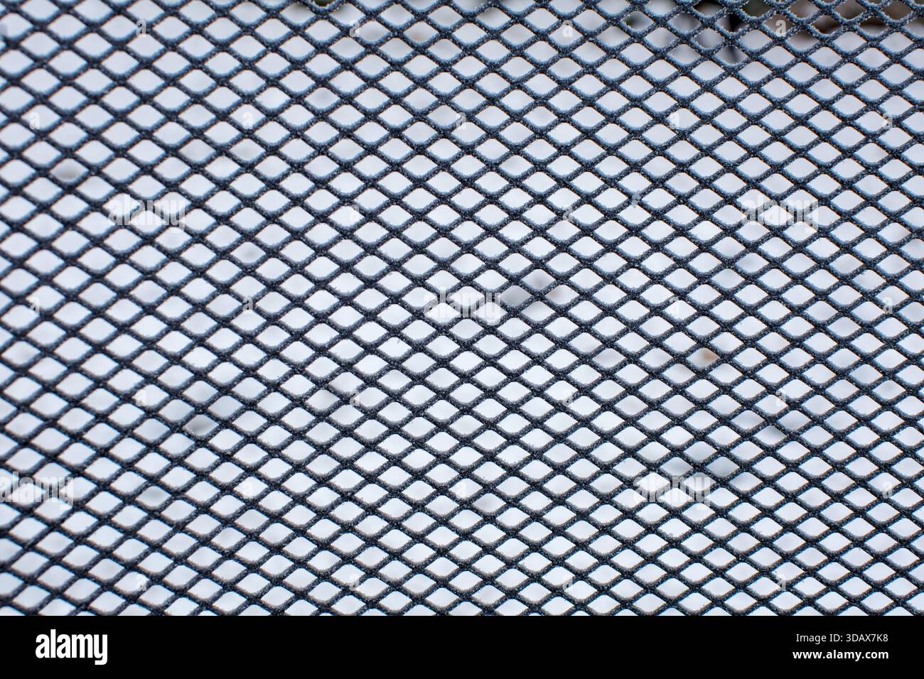 Frostbedecktes Metallgitter mit schneebedecktem Boden dahinter Stockfoto