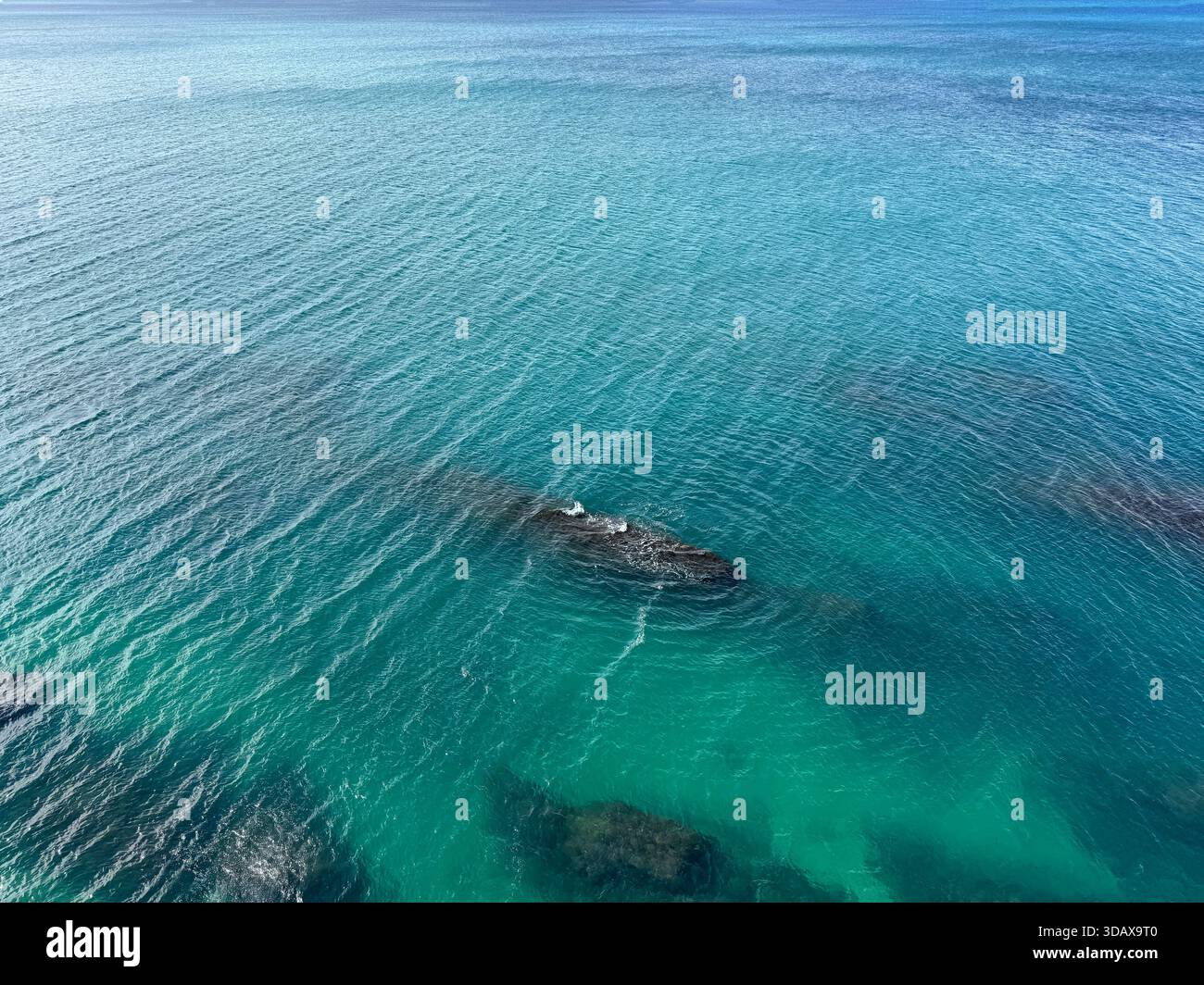 Blick aus der Vogelperspektive auf das wunderschöne Meer und die Unterwasserfelsen Stockfoto