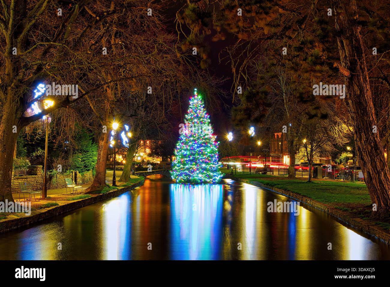 Der Weihnachtsbaum am Fluss Windrush im wunderschönen Dorf Bourton der Cotswolds am Wasser. Stockfoto