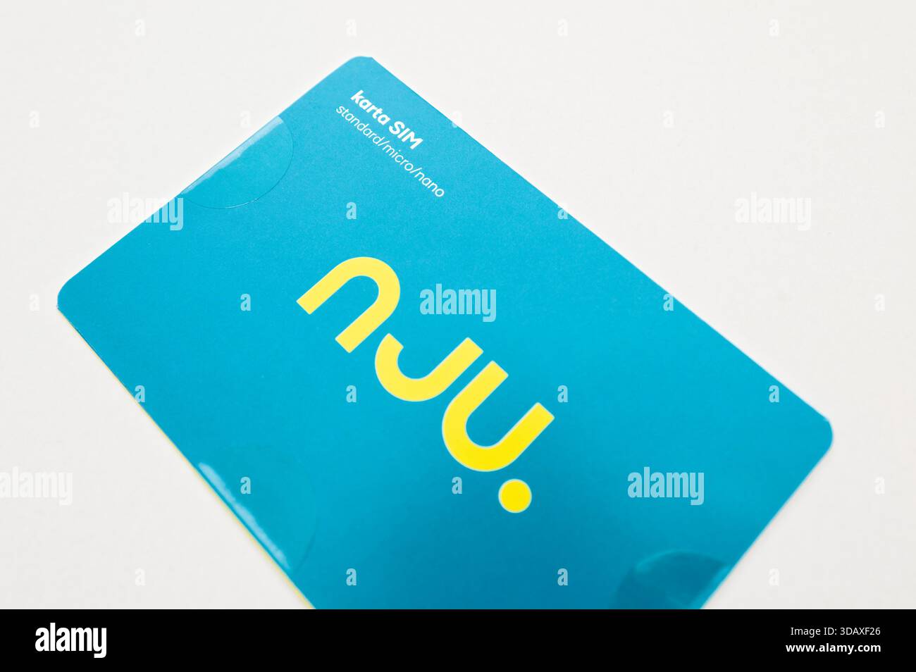 Nju-SIM-Kartenpaket für Mobilgeräte in Blau mit gelbem Logo und „karta SIM“-Text, Nahaufnahme auf hellem Hintergrund. Stockfoto