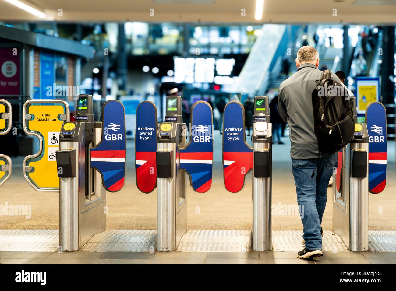 LEEDS, GROSSBRITANNIEN - 12. DEZEMBER 2025. Ein Bahnreisender, der die Fahrkartensperre am Bahnhof Leeds mit der renationalisierten Bahn der britischen Regierung durchquert Stockfoto