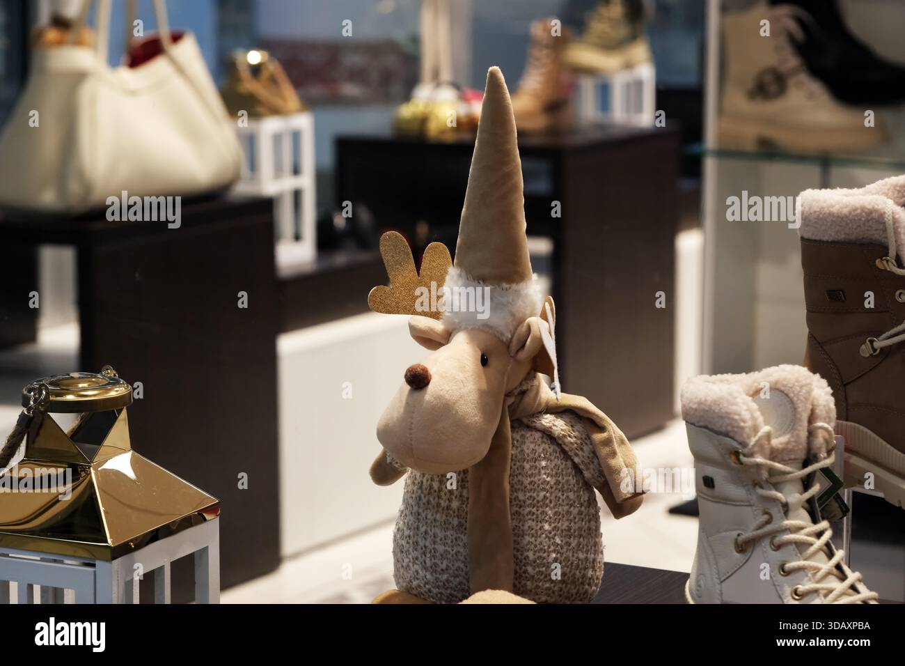 Eine verspielte Rentierfigur ziert ein Schaufenster im Wintergeschäft, das den Urlaubsgeist zum Ausdruck bringt. Kiew, Ukraine. Dezember 2025. Stockfoto