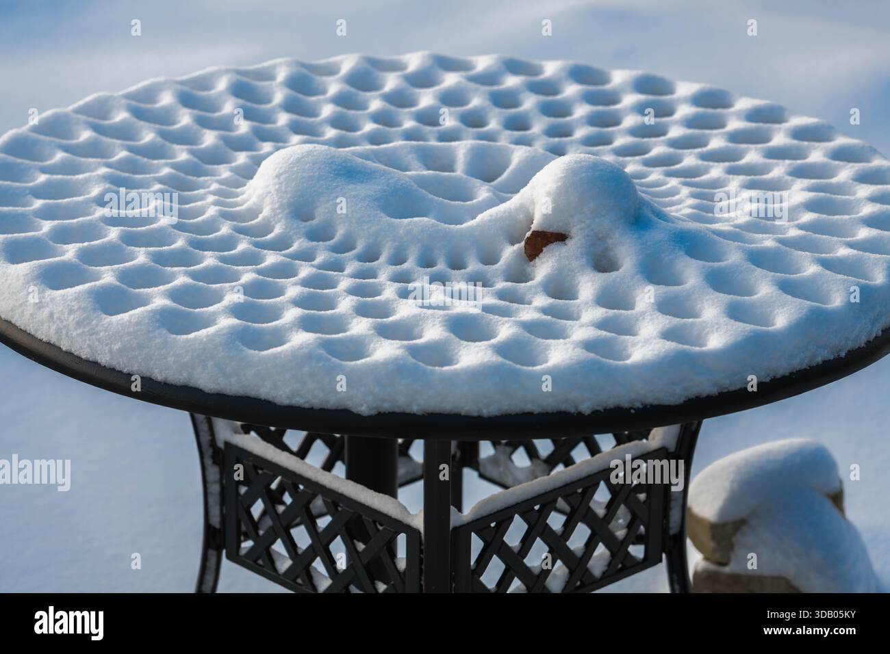 Auf einem Picknicktisch aus Metall bilden sich zarte Schneedesigns, die die Kunstfertigkeit der Natur in einer ruhigen Winterszene in Ludington, Michigan, USA, zeigen Stockfoto
