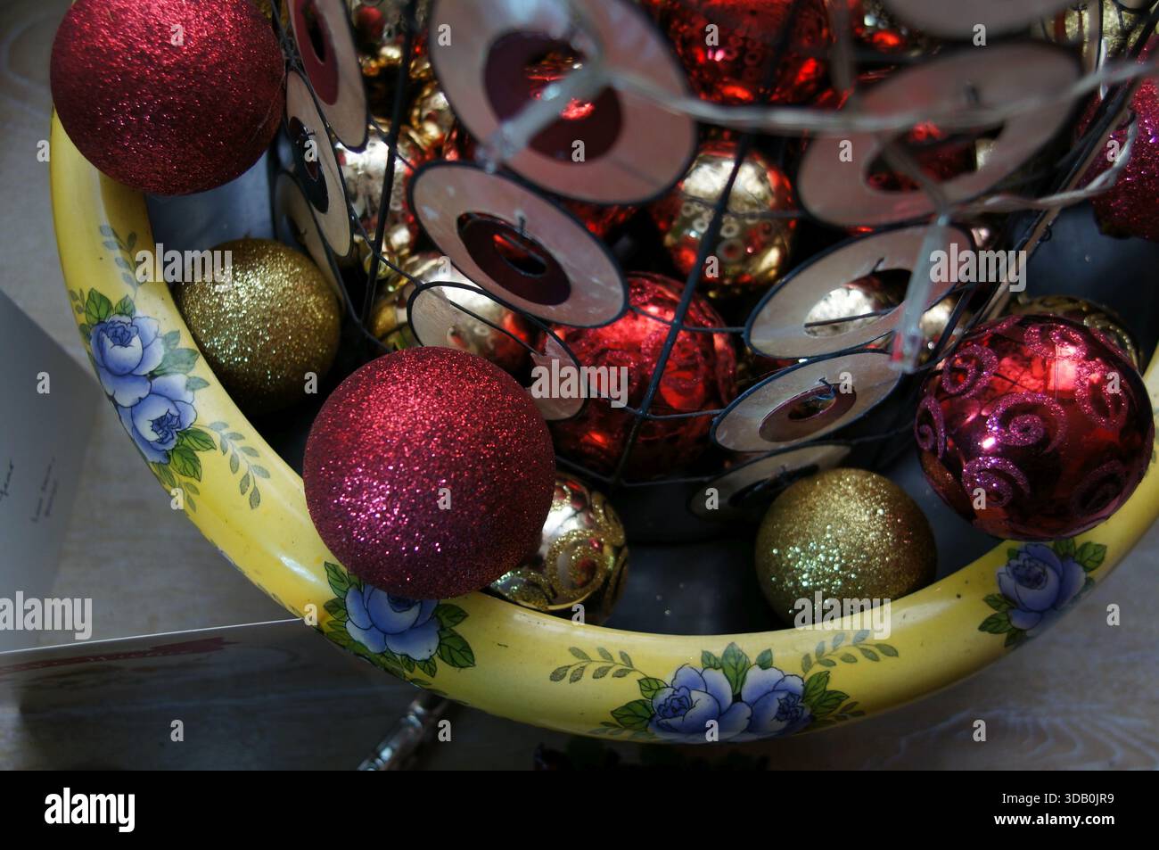Rote und goldene Weihnachtskugeln am Fuß des Minibaums Stockfoto