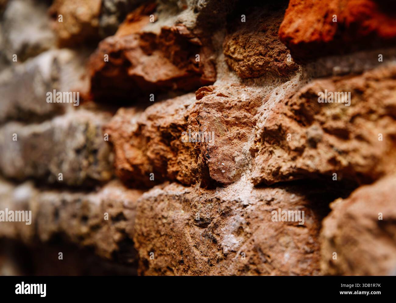 Nahaufnahme einer rustikalen verwitterten Ziegelwand mit verschiedenen Texturen und Farben. Stockfoto