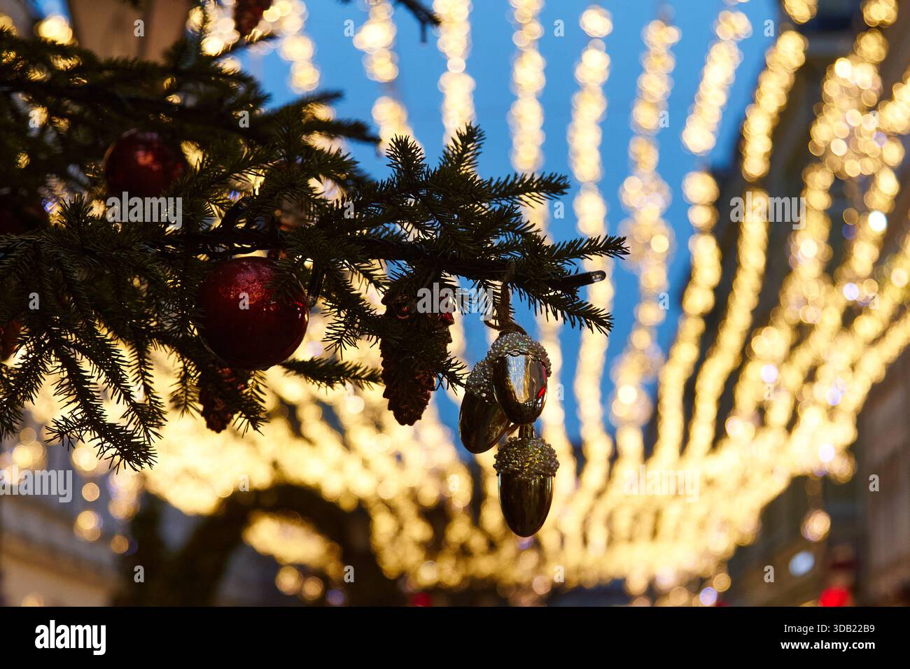 Die Weihnachtsdekoration zeigt Fichtenzweige mit Ornamenten und funkelnden Lichtern und schafft ein gemütliches Ambiente, das perfekt für festliche Feiern und Versammlungen ist Stockfoto