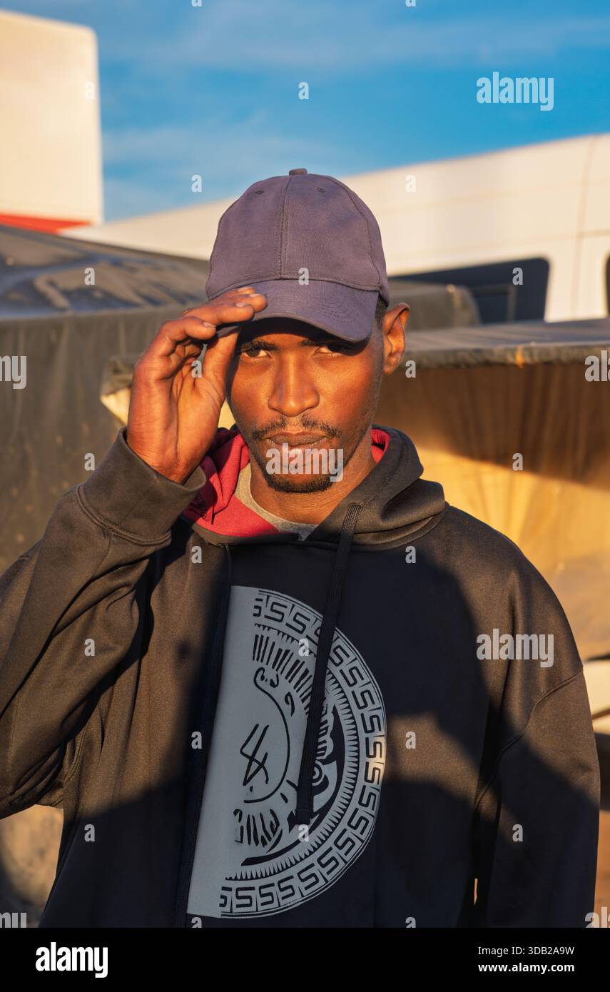 Einzelne junge afrikanische Männer in der Altstadt am Bahnhofshandel bei Sonnenaufgang, Johannesburg City, Südafrika, lässige Kleidung, mit Hut Stockfoto