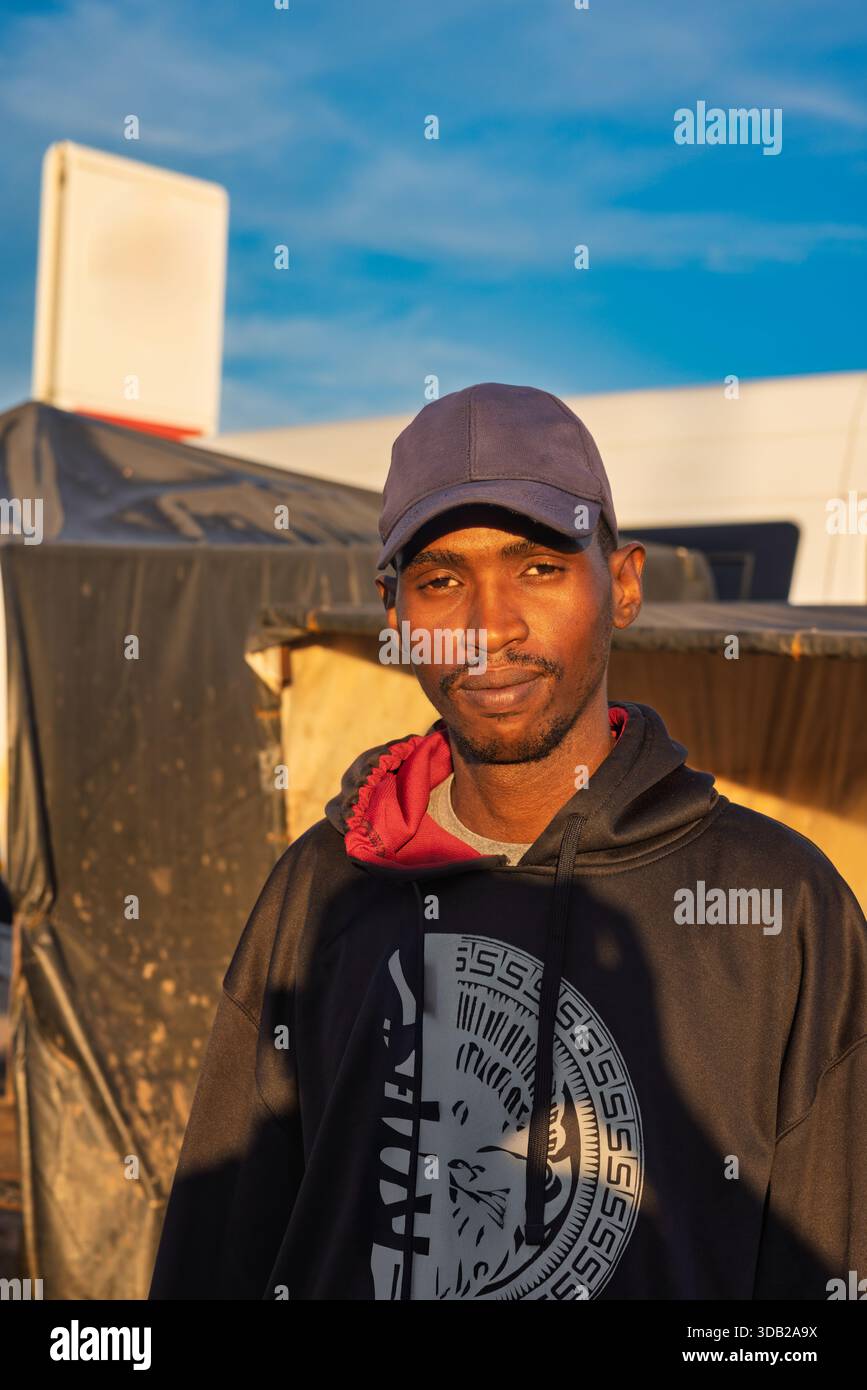 Einzelne junge afrikanische Männer in der Altstadt am Bahnhofshandel bei Sonnenaufgang, Johannesburg City, Südafrika, lässige Kleidung, mit Hut Stockfoto