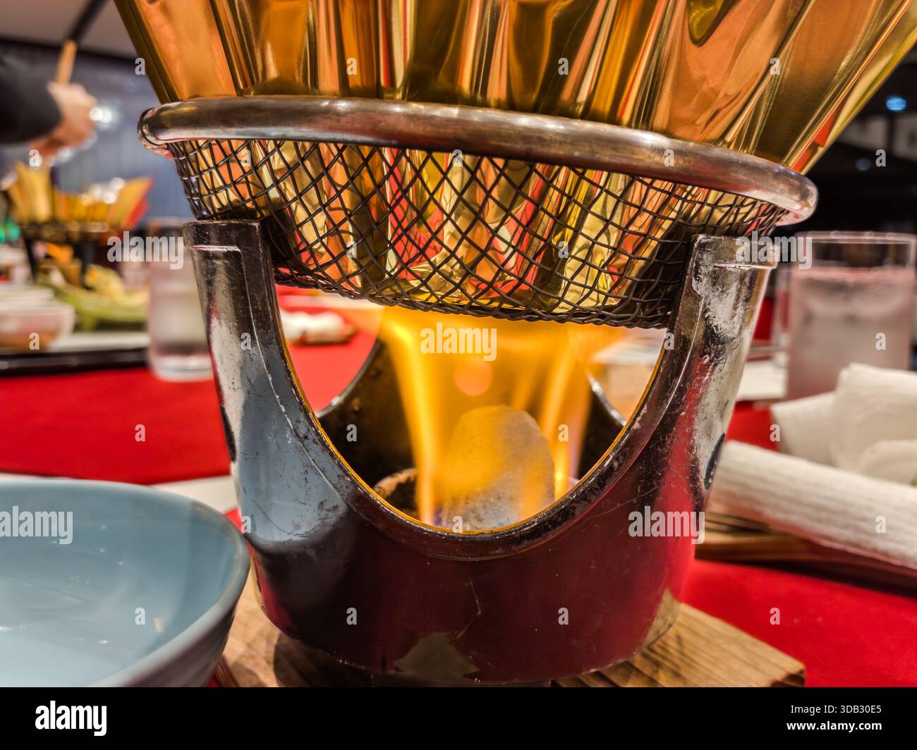Flammen erhitzen einen goldenen Topf auf einem Tisch während des Frühstücks in Hongucho Wataze, Tanabe, Präfektur Wakayama, Japan Stockfoto