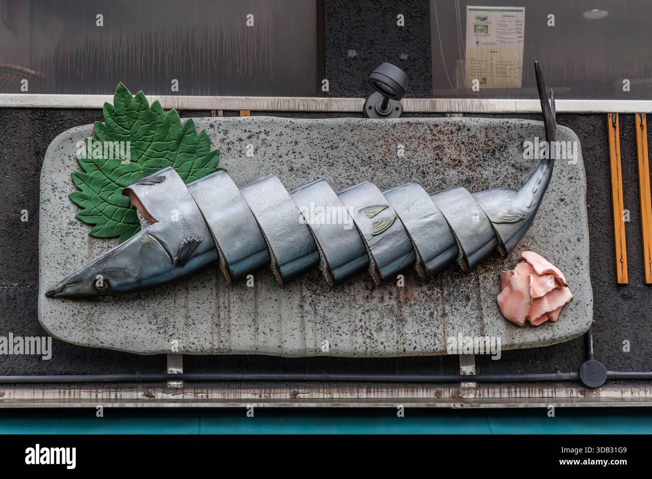 Fischdekoration auf einem Teller mit Blättern und Fleischscheiben vor einem Restaurant in Shingū, Präfektur Wakayama, Japan Stockfoto