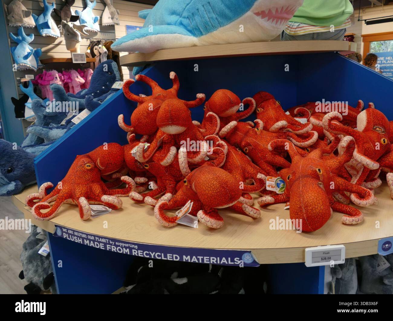 NEWPORT, OREGON – 3. September 2025 – zeigt zahlreiche rote Kraken-Plushies aus recycelten Materialien auf einem runden Regal im Oregon Coast Aquarium Gi Stockfoto
