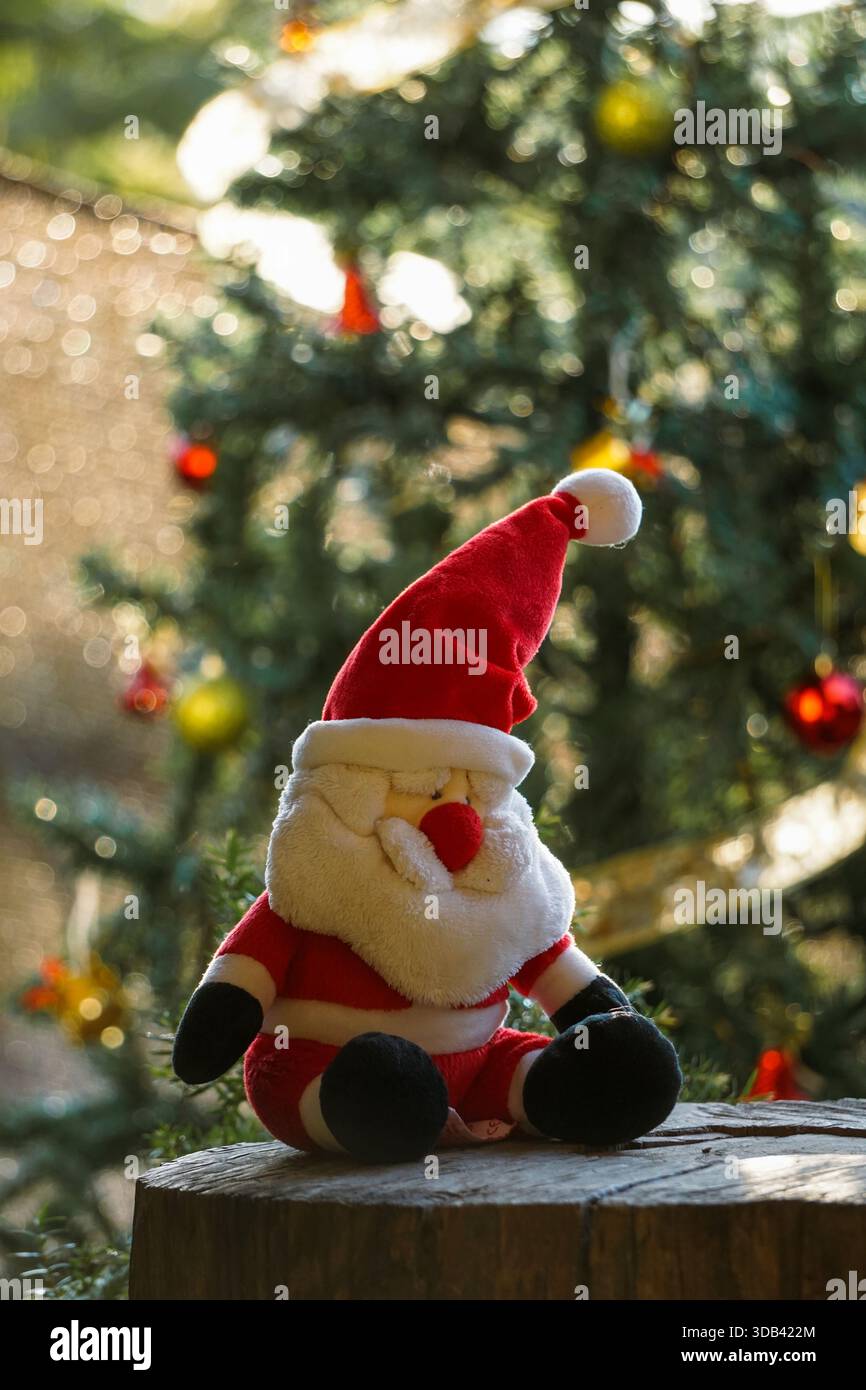 Freude und Schimmer der Weihnachtszeit, mit leuchtend rotem „Merry Christmas“-Schriftzug auf einem grünen Lametta-Baum mit einem warmen Vintage-Lichteffekt. Stockfoto