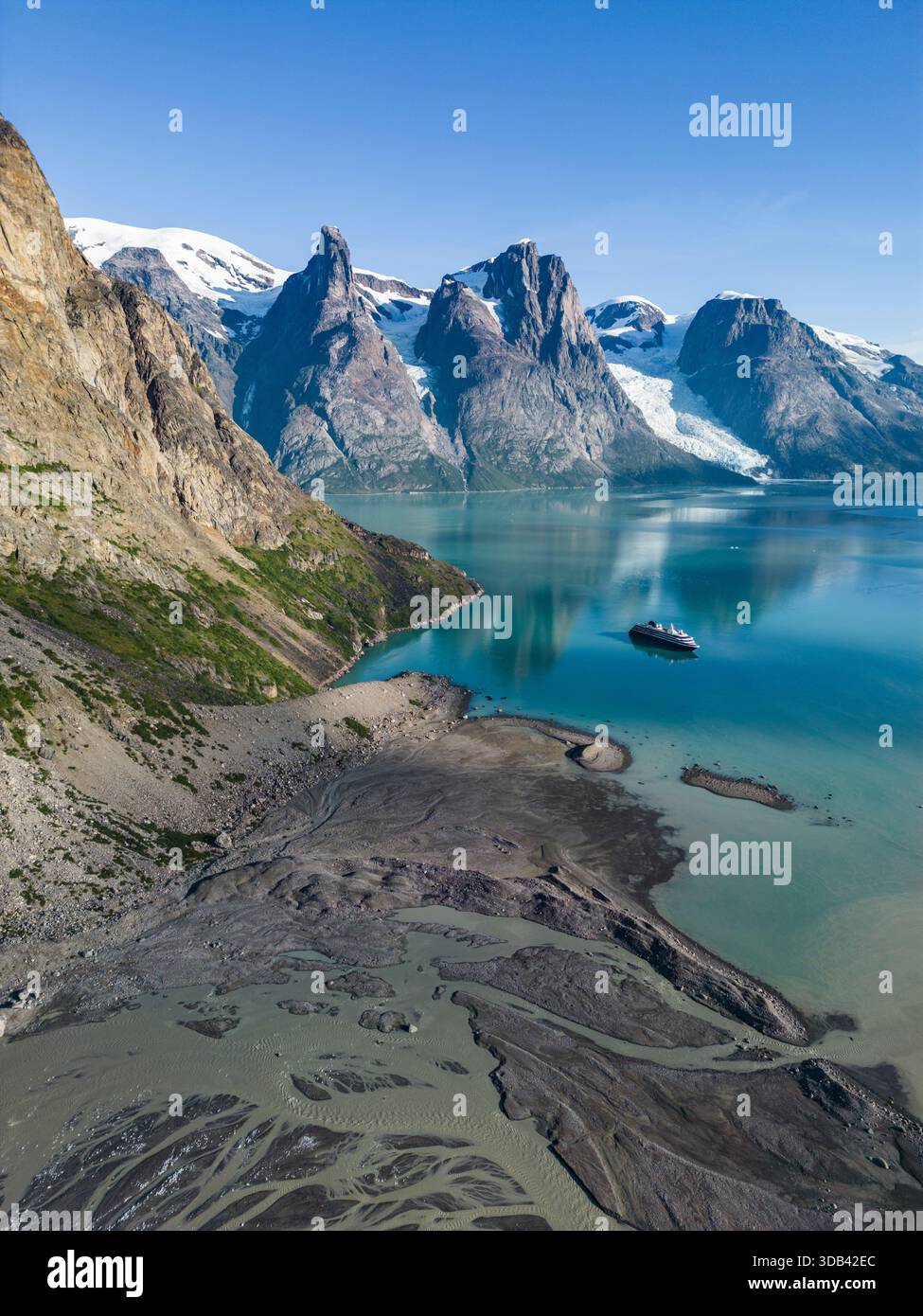 Luftaufnahme des Expeditionskreuzfahrtschiffs World Voyager (Atlas Ocean Voyages) mit Gletscherschmelze im Vordergrund und Bergen dahinter, Evighedsf Stockfoto