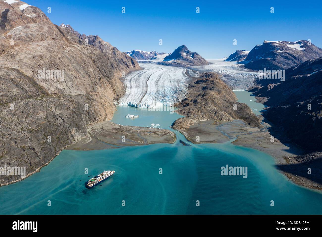 Luftaufnahme des Expeditionskreuzfahrtschiffs World Voyager (Atlas Ocean Voyages) mit einem Gletscher dahinter, Ikamiut Kangerdluarssuat, Queqatta, Grönland, Stockfoto