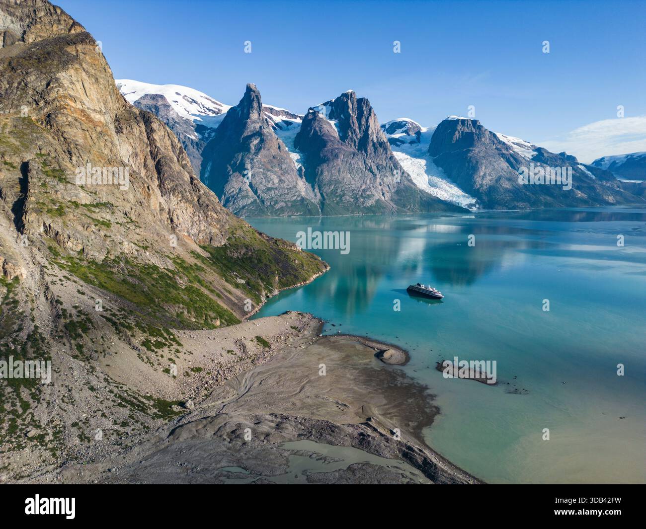 Luftaufnahme des Expeditionskreuzfahrtschiffs World Voyager (Atlas Ocean Voyages) mit Gletscherschmelze im Vordergrund und Bergen dahinter, Evighedsf Stockfoto
