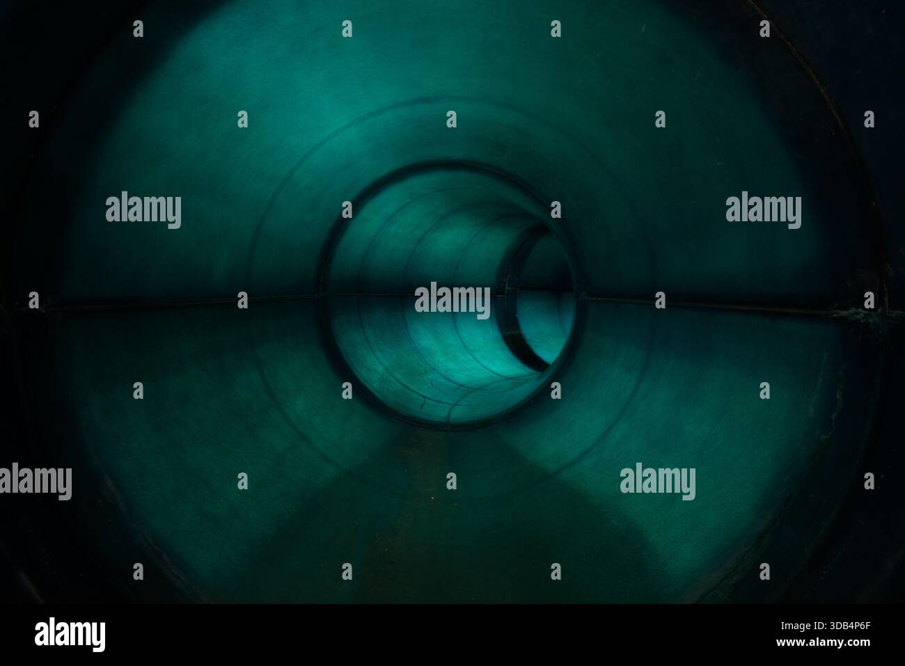 In einem verlassenen Wasserrutschtunnel - Moody Teal Innenraum mit symmetrischem Fluchtpunkt Stockfoto
