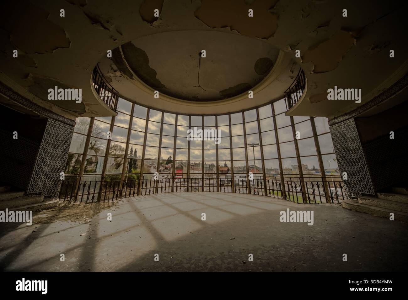 Verlassene kreisförmige Halle mit Panoramafenstern und abblätternder Kuppel in verlassenem Poolgebäude Stockfoto