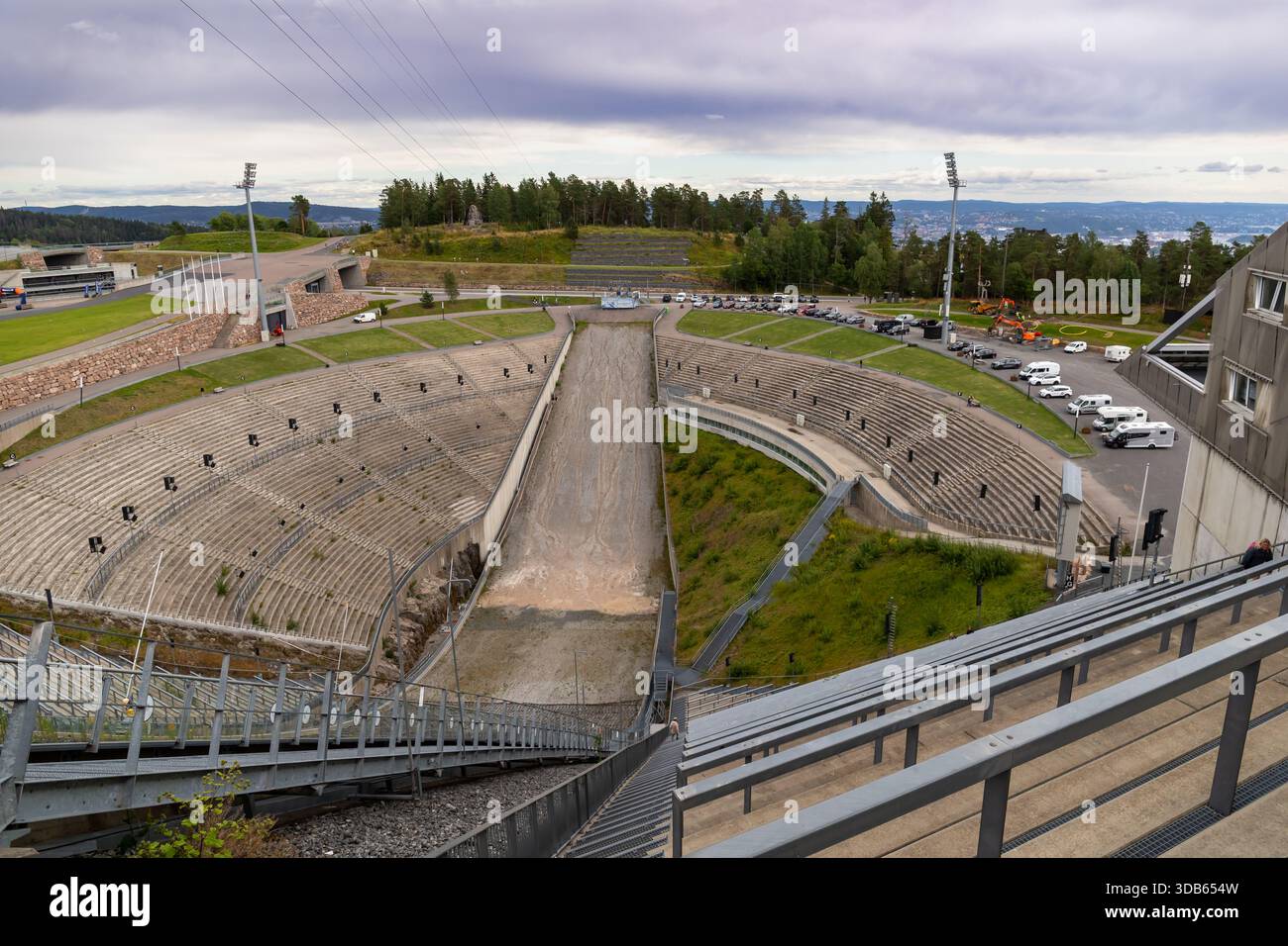 Oslo, Norwegen-11. August 2025: Steiler Blick nach unten auf die Holmenkollbakken Arena mit leeren Sitzplätzen und Schottersprungzone im Sommer. Stockfoto
