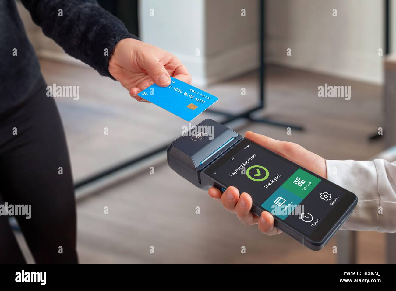 Kontaktlose Kartenzahlung genehmigt am mobilen POS-Terminal mit digitalen Schnittstellenoptionen, die moderne Einzelhandelstechnologie und bargeldlose Kasse veranschaulichen Stockfoto