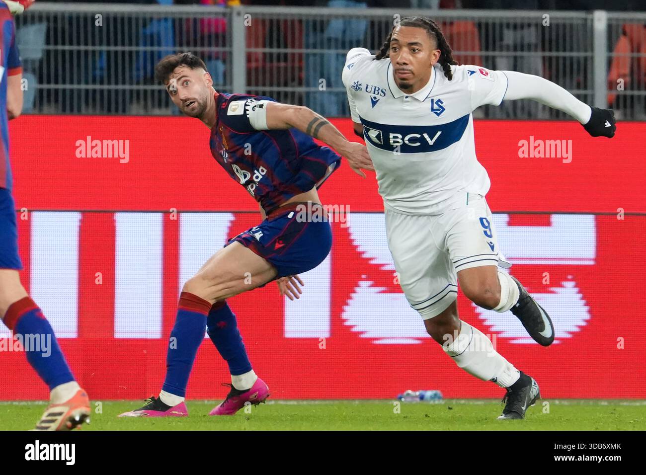 Basel, Schweiz. Dezember 2025. 14.12.2025, Basel, St. Jakob-Park, Super League: FC Basel - FC Lausanne-Sport, Ballkampf zwischen #9 Theo Bair (Lausanne-Sport) und #31 Dominik Schmid (Basel) (Foto: Pascal von Büren/Just Pictures/SIPA USA) Credit: SIPA US/Alamy Live News Stockfoto