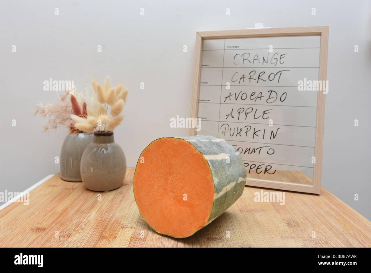Ein Brett und ein Kürbis zeigen an, welches Essen am Freitag zu essen ist Stockfoto