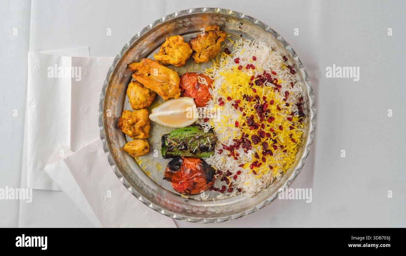Persisches Zereshk-Polo mit gegrilltem Joojeh-Kebab, Safranreis und Berberitze, serviert mit gegrilltem Gemüse. Stockfoto