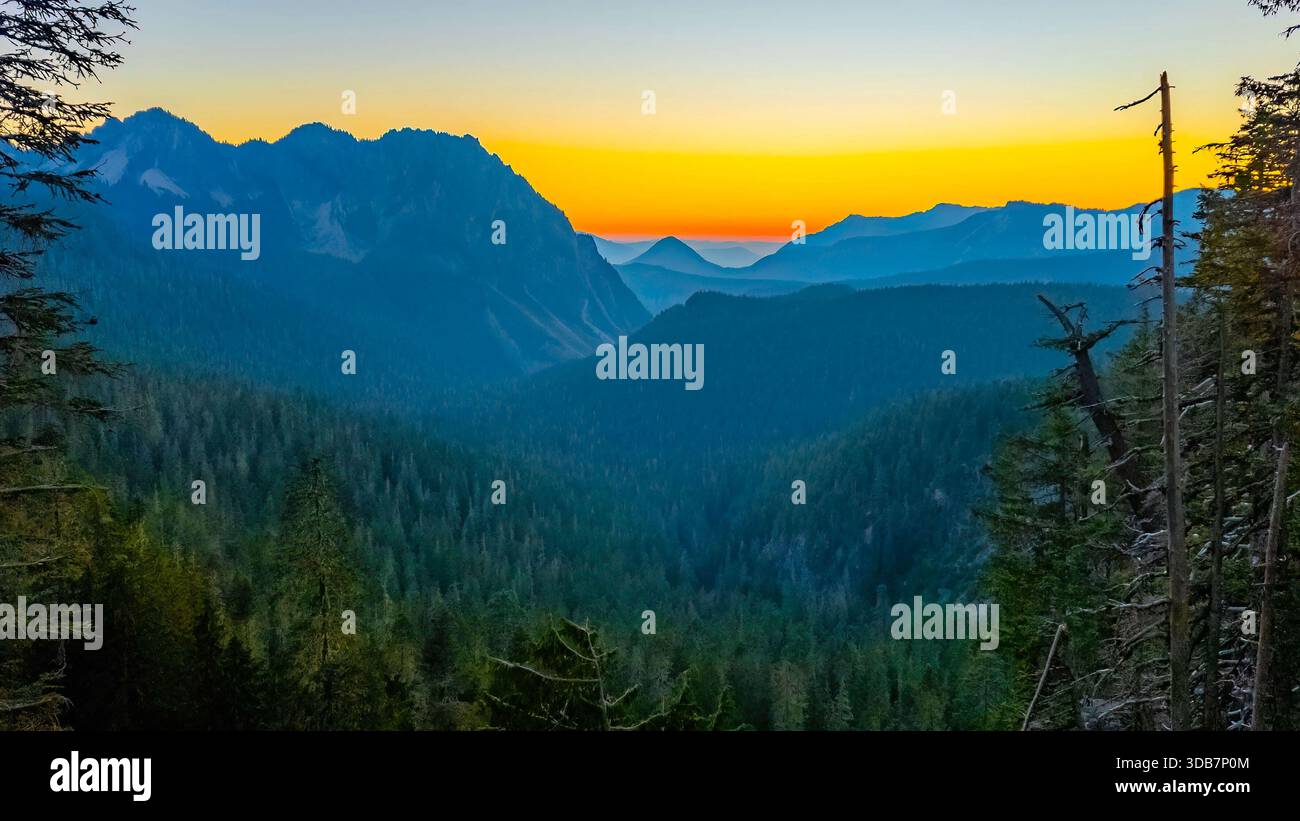 Ein farbenfroher Sonnenuntergang bietet einen herrlichen Blick auf den Mazama Ridge und den fernen Mount Adams, von Mount Rainiers Inspirationspunkt aus gesehen. Stockfoto