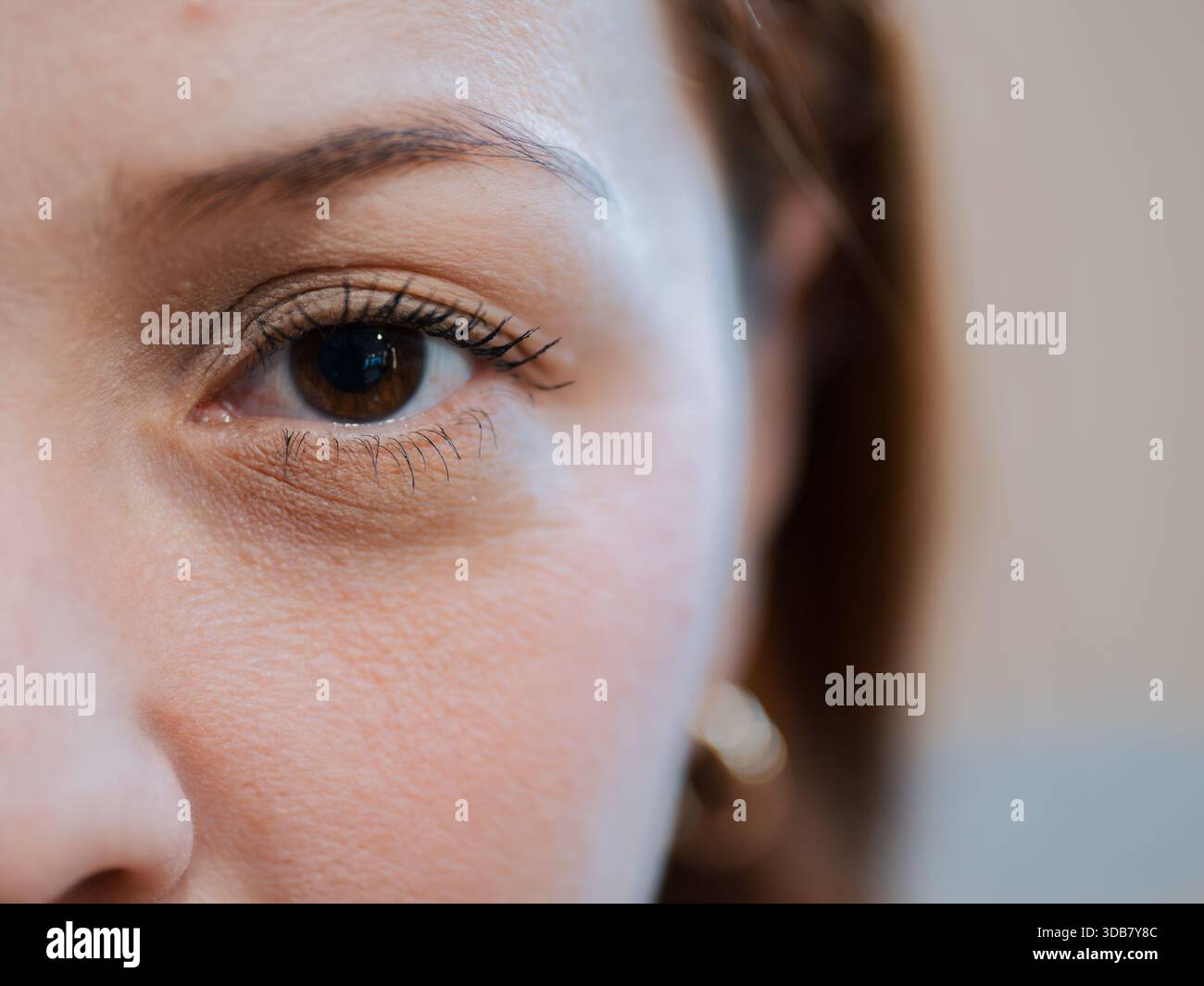 Nahaufnahme mit halbem Gesicht, die das Auge und die natürliche Haut einer Frau hervorhebt. Das Konzept von Schönheit, Vision und persönlicher Identität. Stockfoto