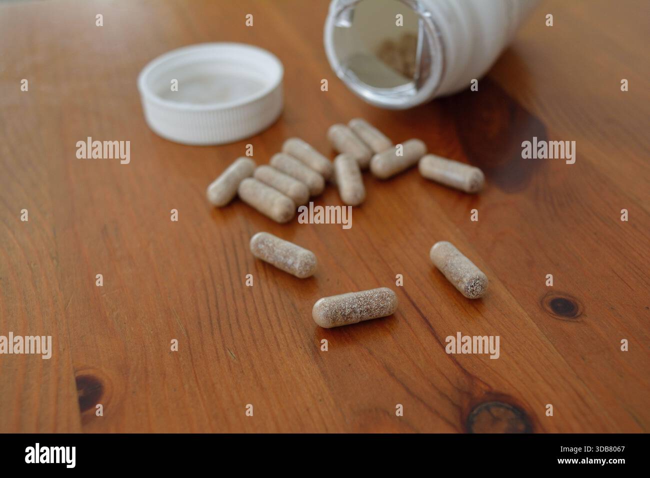 Ergänzungskapseln, die auf einer Holzplatte verschüttet werden Stockfoto